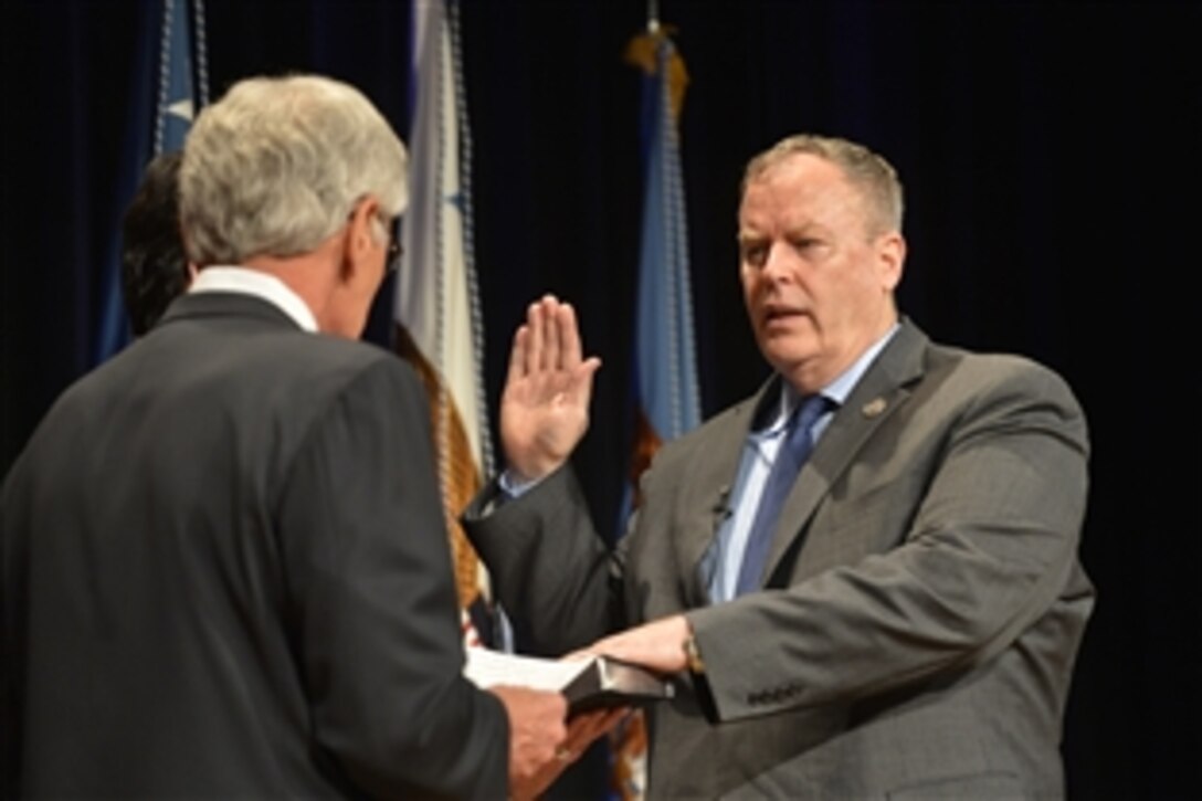 Defense Secretary Chuck Hagel, left, administers the oath of office to newly installed Deputy Defense Secretary Bob Work during a welcome ceremony at the Pentagon, June 9, 2014.
