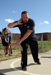 Pennsylvania Army National Guard veteran Sean Hook demonstrates the proper shot put throwing stance for a group of Fort Carson, Colo., middle school students April 26, 2012. Hook will represent the Army at the 2012 Warrior Games from April 30 to May 05, 2012. The Warrior Games bring together wounded, ill and injured service members from the Air Force, Army, Coast Guard, Marine Corps, Navy, National Guard, Reserve and Special Operations Command in a sporting competition hosted by the U.S. Olympic Committee.