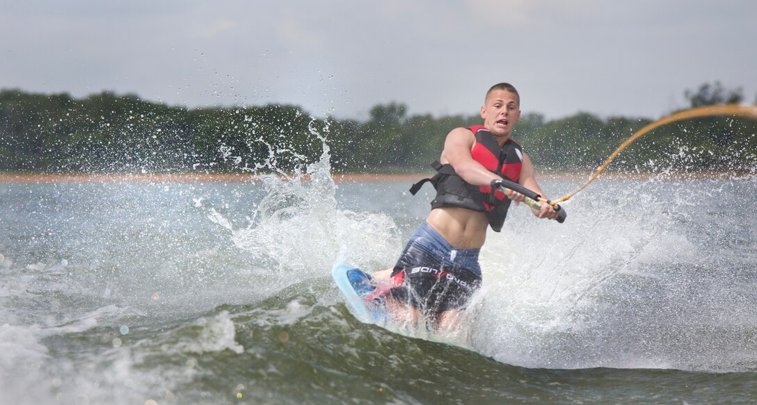 Pfc. Brandon D. Potter, an administration clerk with the 8th Marine Corps District, knee boards behind a boat at Eagle Mountain Lake, in Fort Worth, Texas, May 30, 2014.