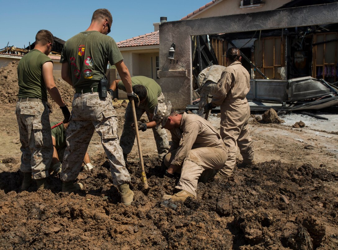Marines from Marine Wing Support Squadron 371 and other elements of 3rd Marine Aircraft Wing from Marine Corps Air Station Yuma, Ariz., sift through the debris and inspect pieces of wreckage from the AV-8B Harrier II crash site  during the cleanup process in Imperial, Calif., Monday. Frederick Daniels, the director for range compliance at MCAS Yuma, is in charge of the remediation process to clean up the crash site once the effort is turned over to the City of Imperial. He will work with contractors to takes samples and tests of the site to ensure the removal of contaminants from the soil, groundwater and surface.