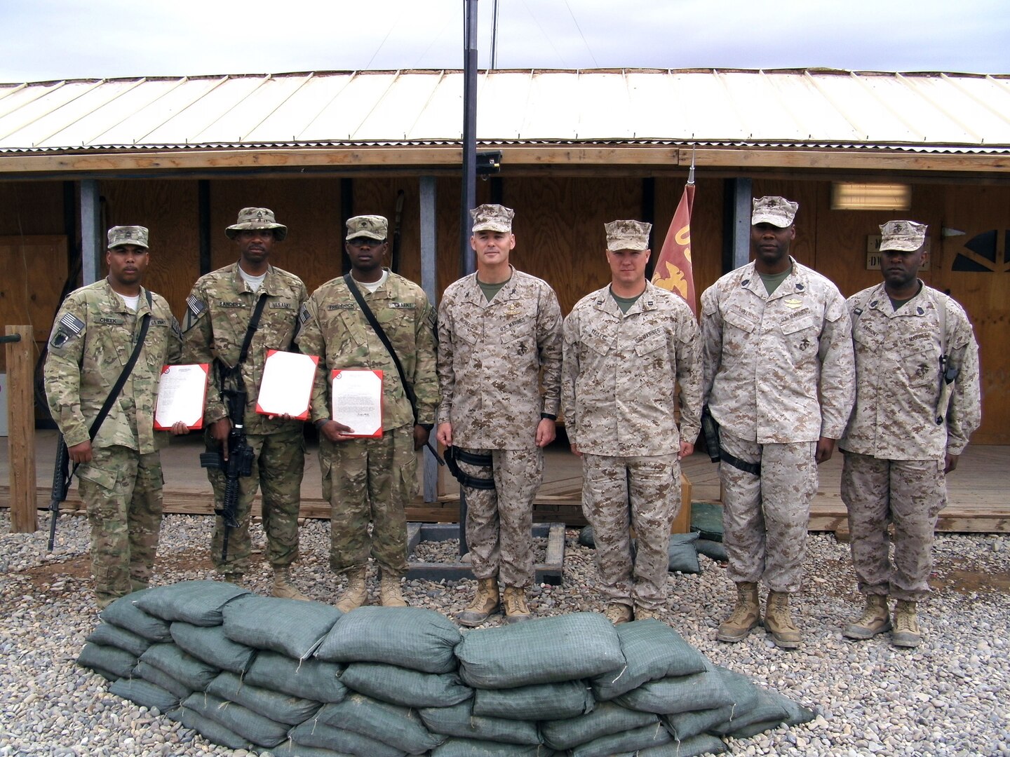 Soldiers of the 113th Sustainment Brigade are presented certificates of appreciation from Marine Col. Christopher Michelsen, commander of Marine Corps Logistics Command (Forward), Camp Dwyer, Afghanistan March 13, 2012. From left, Army Sgt. 1st Class Kendall Cheek, Staff Sgt. Dirkson Sanders, and Spc. Raymond Frederick, developed a training plan and presented a driver training course to Marines and civilians on Camp Dwyer.