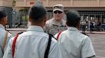 Spc. Joseph Winsor, assigned to Medical Detachment 1, Arizona Army National Guard, inspects Junior ROTC cadets competing in the drill showdown during the Desert Classic State Drill Meet at Alhambra High School in Phoenix.