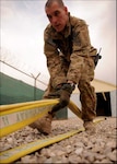 Kentucky Army National Guard Sgt. Andrew Coomer, a firefighter with the 176th Firefighting Team, prepares a hose for stowage following a training exercise in Helmand Province, Afghanistan. The 176th FFT have been working with Afghan National Army firefighters as a way to further the skills of the Afghan firefighters.