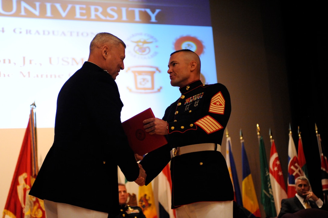 U.S. Marine Corps General John M. Paxton, Assistant Commandant of the Marine Corps, presents Sgt. Maj. Scott D. Hamm with a master’s in military studies after he graduated from Marine Corps Command and Staff College on June 4, at Marine Corps Base Quantico. Hamm and Sgt. Maj. Jonathan Henry are the first enlisted Marines to be admitted to and graduate from the Command and Staff College, which is part of Marine Corps University.  (U.S. Marine Corps photo by Lance Cpl. Samuel Fernandez/Not Released)