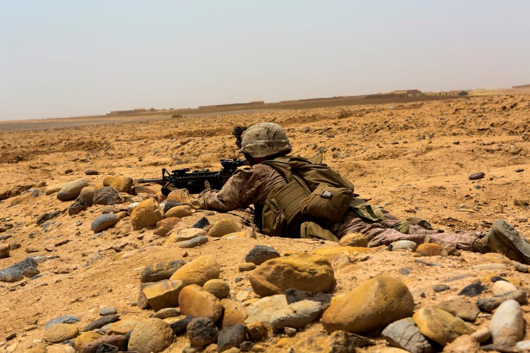 Corporal Alex Houle, a team leader with Charlie Company, 1st Battalion, 2nd Marine Regiment, and a native of Greenwood, South Carolina, posts security in the prone position during a reconnaissance patrol near Patrol Base Boldak in Helmand province, Afghanistan, May 15, 2014. A low shooting position gives Houle stability and a low silhouette to ensure the safety of his fellow Marines and sailors. (U.S. Marine Corps Photo by Cpl Michael Dye/Released)