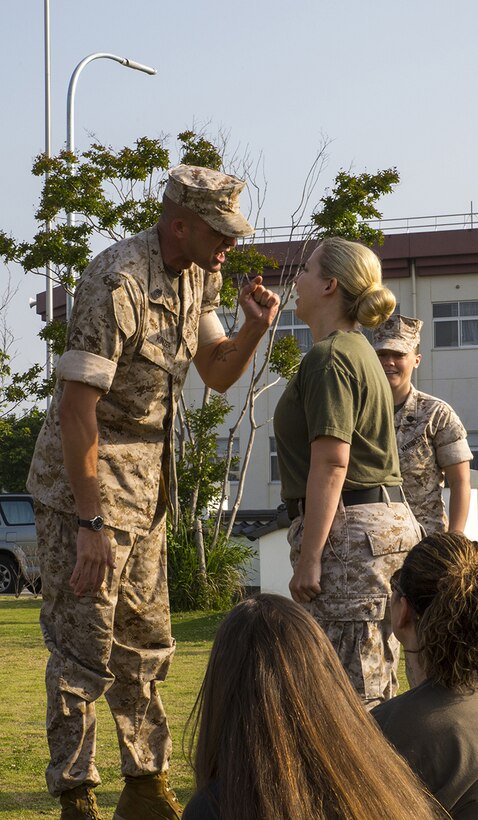 Sgt. Maj. Coleman R. Kinzer corrects at Katherine A. West, Headquarters and Headquarters Squadron Jane Wayne Day participant, for not standing while addressing him aboard Marine Corps Air Station Iwakuni, Japan, May 31, 2014. West is also the family readiness officer for H&HS and coordinator of the event.