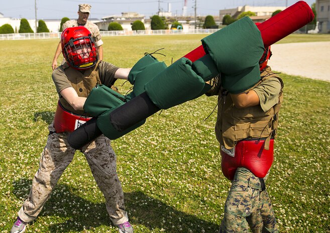 Spouses battle in a Pugil Sticks match during Headquarters and Headquarters Squadron Jane Wayne Day aboard Marine Corps Air Station Iwakuni, Japan, May 31, 2014. The Pugil Sticks competition took place after the modified Combat Fitness Test and concluded the day’s events.