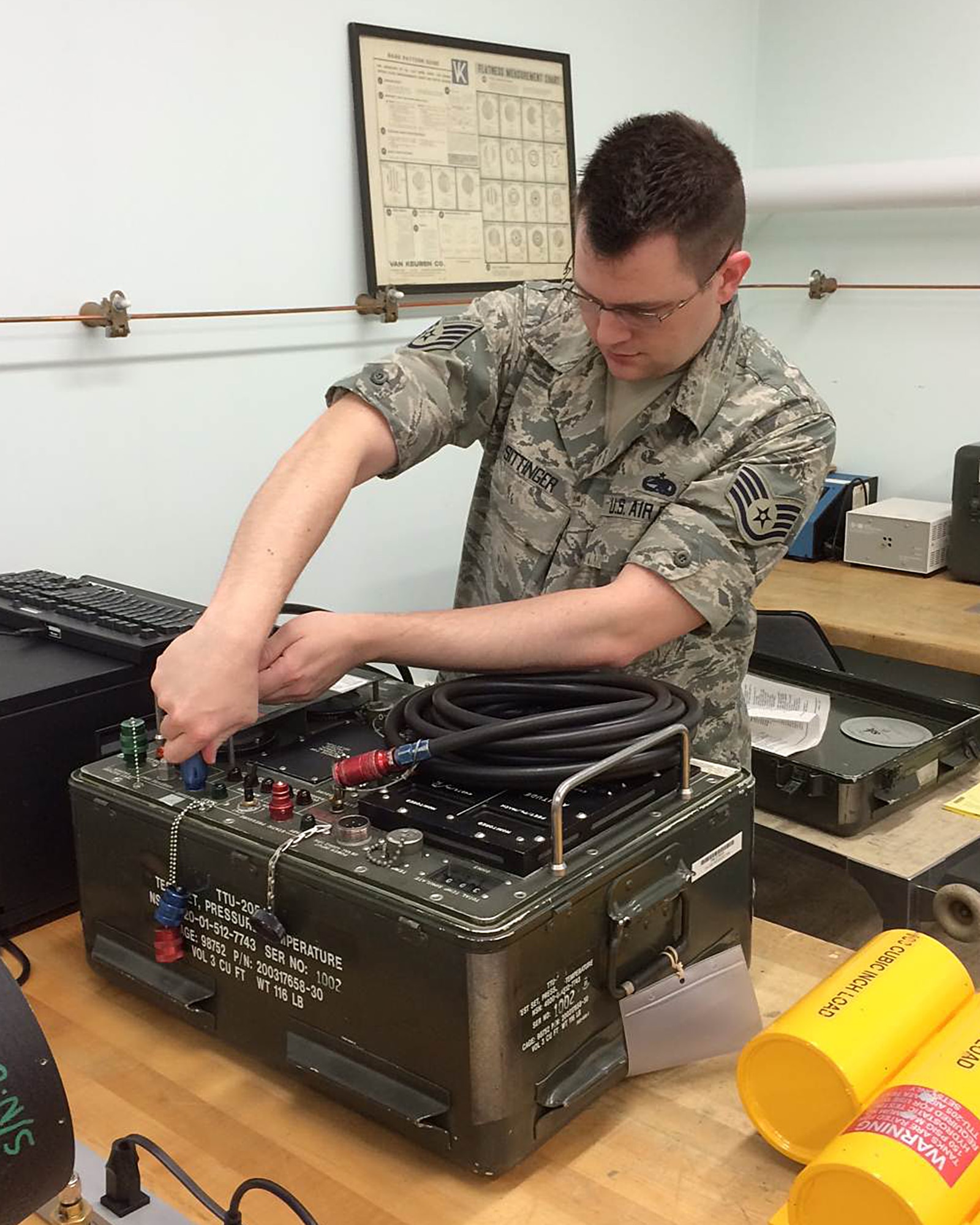 Staff Sgt. Peter Sittinger, 374th Maintenance Squadron precision measurement equipment laboratory technician, unplugs a cord from a pressure tester at Yokota Air Base, Japan. Pressure testers are used on every airframe to determine if the flight sensors are correct. (Courtesy photo/Released)
