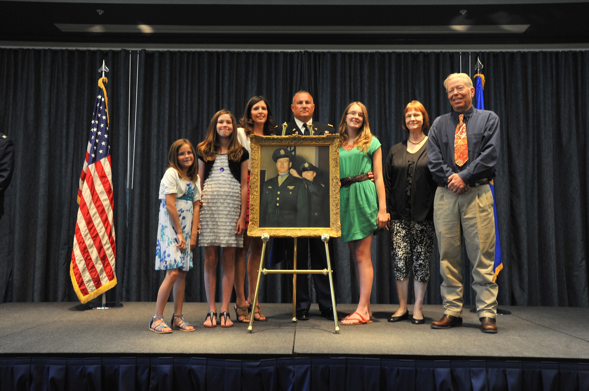 Col. Brian Newberry, 92nd Air Refueling Wing commander, joins the Morgan family to unveil a portrait of 2nd Lt. John "Red" Morgan, the 92nd Bombardment Group's only Medal of Honor recipient, June 6, 2014 at Fairchild Air Force Base, Wash., during the dedication ceremony. Morgan was awarded the Medal of Honor for his actions on a bombing mission over Nazi Germany in 1943 while he was a copilot of a B-17 Flying Fortress.  (U.S. Air Force photo by Staff Sgt. Veronica Montes/Released)