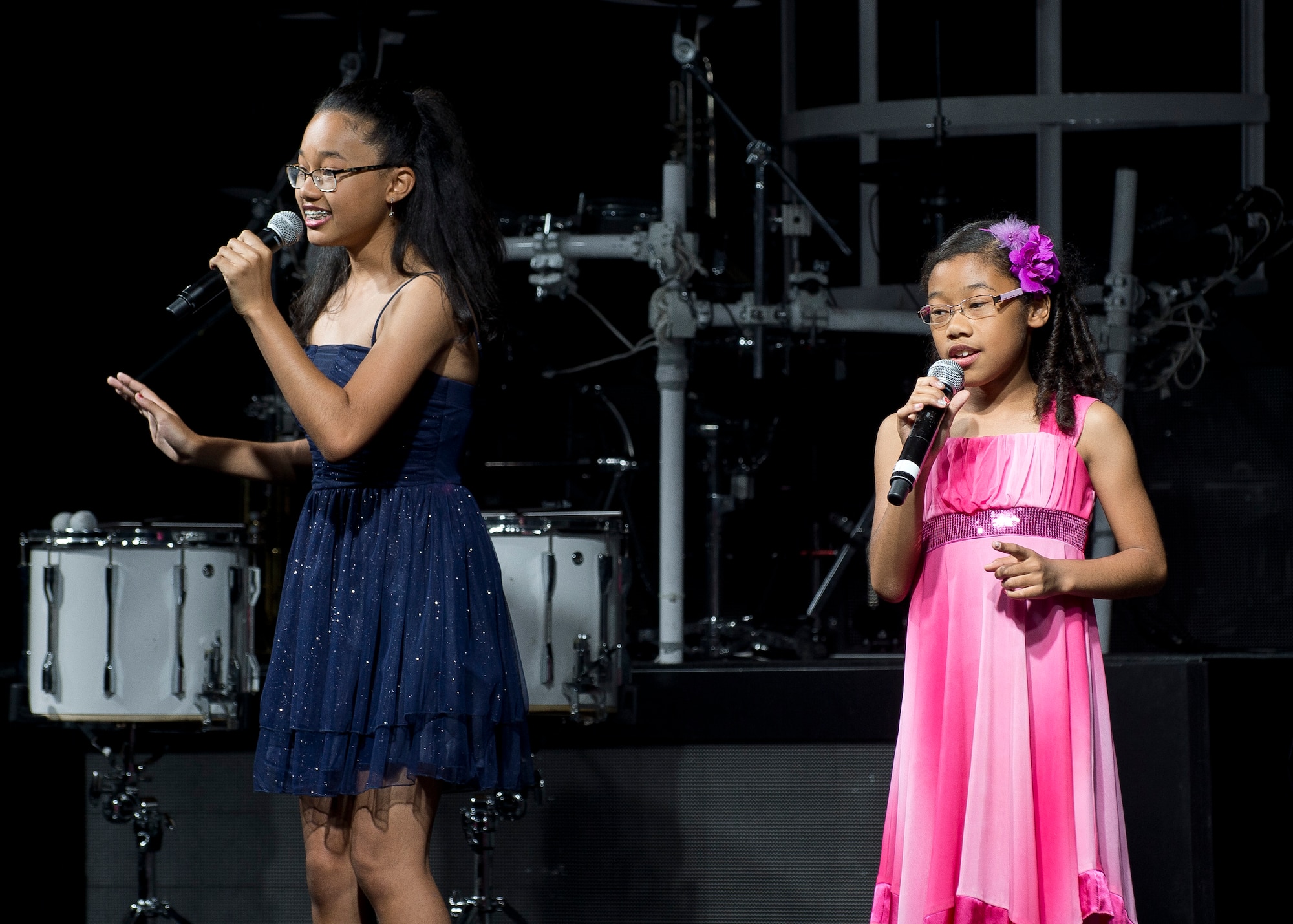 Miwa Tucker (left), 13, and her sister Kotomi, 10, sing "A Girl Like You," as the opening act of this year's Tops in Blue performance June 8 at the base theater. Last October, Edwards AFB conducted a local talent show called U Got Talent, an Air Force Family & Teen Talent Contest. Kotomi and Miwa won in both their age categories and as a duet.  A DVD of the winners at the base level were forwarded to the Air Force Entertainment Head Quarters in San Antonio, Texas. Kotomi and Miwa were asked to perform as the opening act before Tops in Blue went on stage. (U.S. Air Force photo by Ethan Wagner)      
