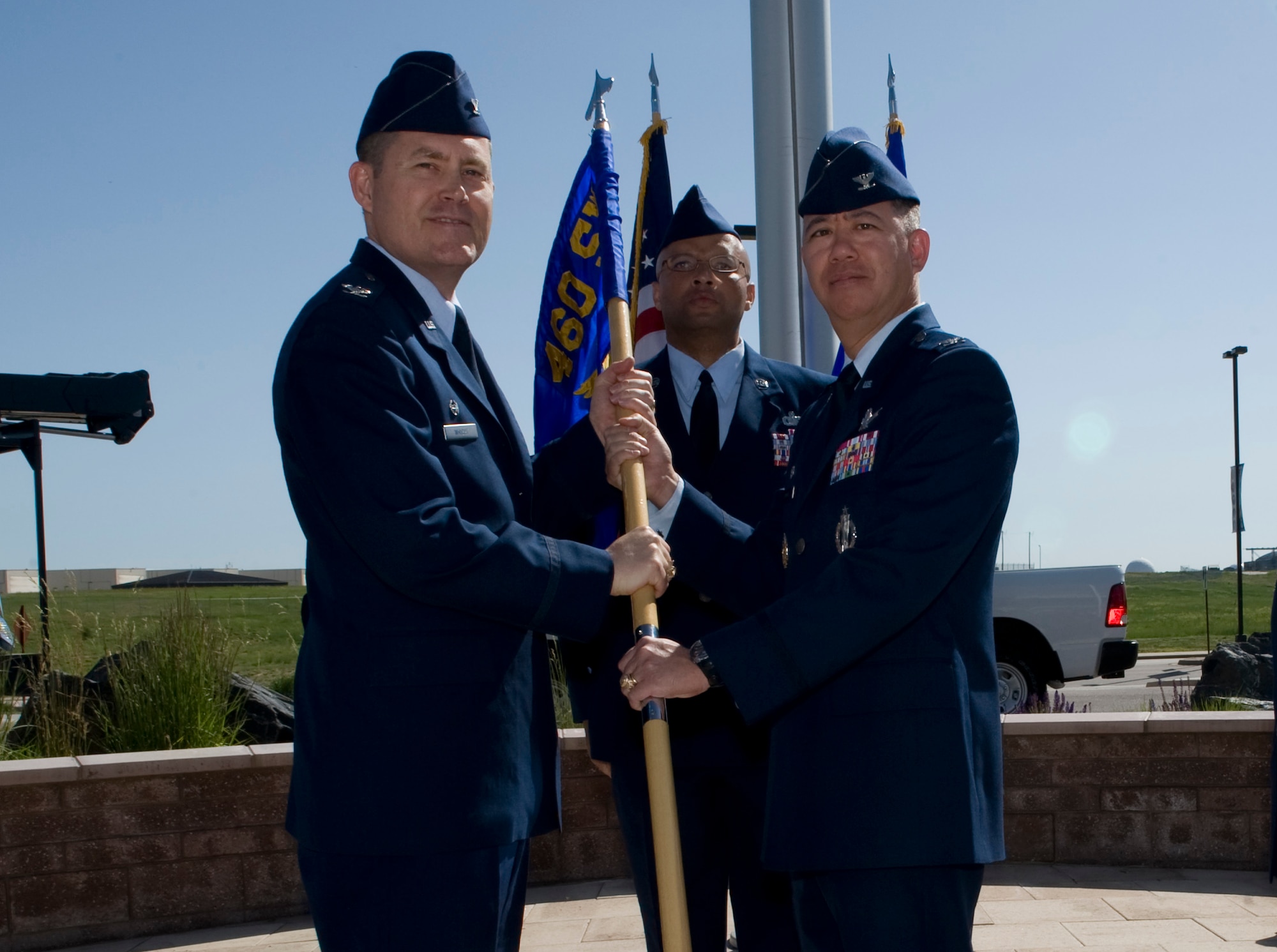 Col. Daniel Wright, 460th Space Wing commander, receives the 460th Mission Support Group flag from Col. Robert Uemura to symbolize his relinquishing of command of the 460th MSG June 10, 2014, at the 460th SW Headquarters on Buckley Air Force Base, Colo. During the ceremony, Col. Rose Jourdan assumed command of the 460th MSG from Uemura, who served as the commander since June 2012. (U.S. Air Force photo by Senior Airman Phillip Houk/Released)