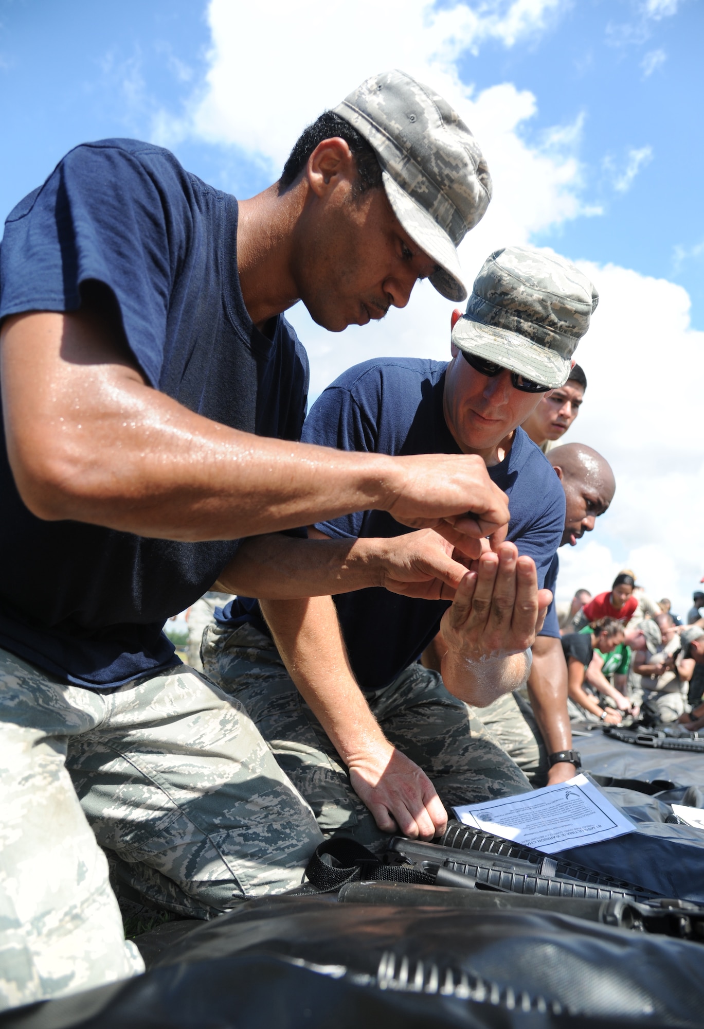 The Fire Department team members, Tech. Sgt. Waymon Brown, 81st Force Support Squadron, and Master Sgt. Walter Shutler, Keesler Firefighter, assemble a  weapon in the “Assembled Weapons” challenge during the 81st Training Wing Warrior Challenge hosted by the 81st Mission Support Group June 6, 2014, at the Triangle Track, Keesler Air Force Base, Miss. The event was held in memory of the 70th anniversary of The Normandy Invasion also known as D-Day.  It consisted of nine six-member teams racing in a competition designed to take them through various aspects of a deployment. (U.S. Air Force photo by Kemberly Groue)