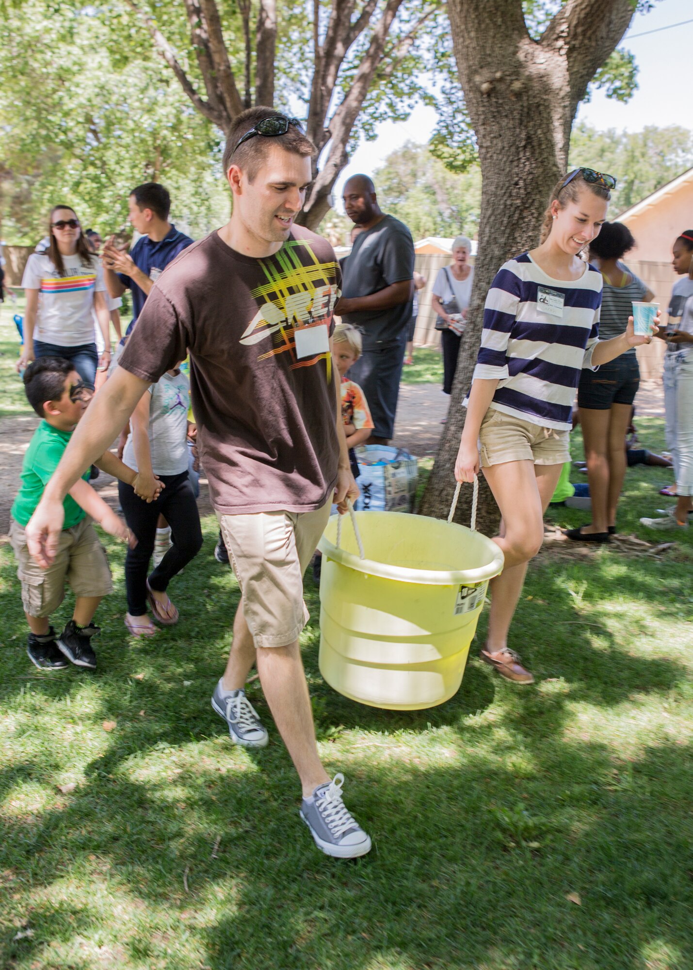 Capt. Jacob Debevec, 412th Test Wing, executive officer and Base Chapel youth leader, and a volunteer carry a bucket in preparation for the water balloon toss.(Courtesy photo by Edward Cannon)