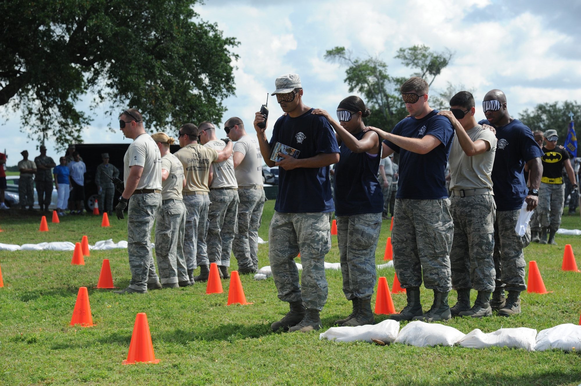Ricky & The Bayonets team and the Fire Department team make their way through the Communications” challenge during the 81st Training Wing Warrior Challenge hosted by the 81st Mission Support Group June 6, 2014, at the Triangle Track, Keesler Air Force Base, Miss. The challenge consisted of one team member leading the rest of the team through a blindfolded course via handheld radio. The Warrior Challenge event was held in memory of the 70th anniversary of The Normandy Invasion also known as D-Day. (U.S. Air Force photo by Kemberly Groue)