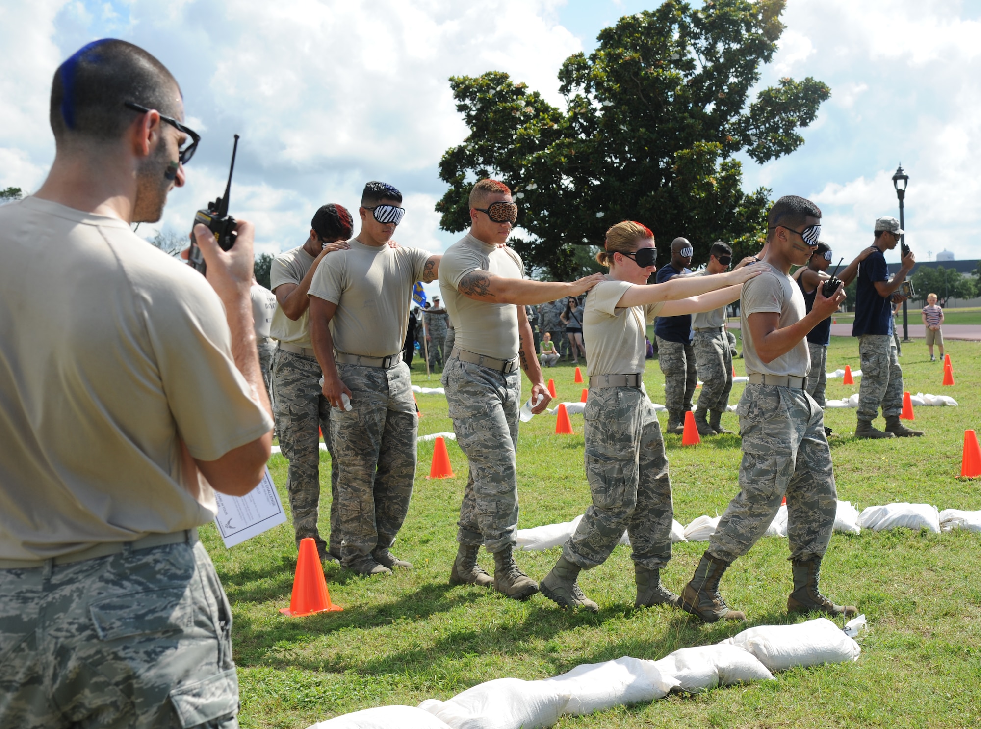Staff Sgt. Daniel Storm leads his team, The Logistics Readiness Squadron Warriors, in the Communications” challenge during the 81st Training Wing Warrior Challenge hosted by the 81st Mission Support Group June 6, 2014, at the Triangle Track, Keesler Air Force Base, Miss. The challenge consisted of one team member leading the rest of the team through a blindfolded course via handheld radio. The Warrior Challenge event consisted of nine six-member teams racing in a competition designed to take them through various aspects of a deployment.  (U.S. Air Force photo by Kemberly Groue)