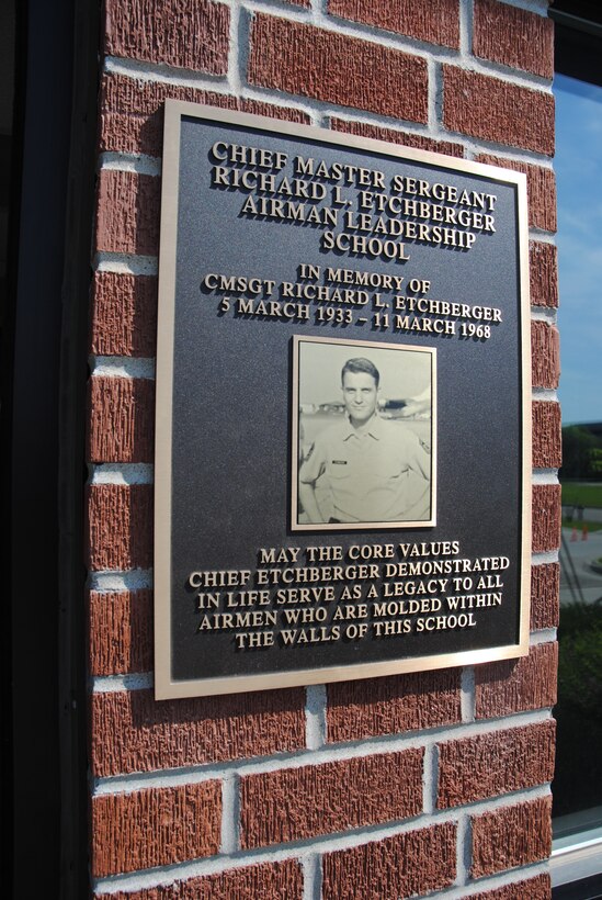 A golden plague with the image of Chief Etchberger shines much bright being recently unveiled during the Chief Master Sgt. Richard L. Etchberger Airman Leadership School building dedication ceremony held June 4, 2014, on Grand Forks Air Force Base, N.D. The lower part of the inscription reads, "May the core values Chief Etchberger demonstrated in life serve as a legacy to all Airmen who are molded within the walls of this school." (U.S. Air Force photo/Staff Sgt. Luis Loza Gutierrez) 

