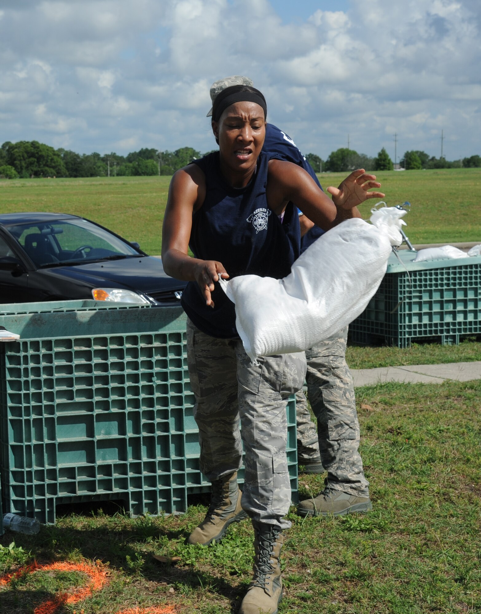 The Fire Department team member, Master Sgt. Tomeika Frazier, 81st Force Support Squadron, tosses a sandbag in the “Sandbag Stacking” challenge during the 81st Training Wing Warrior Challenge hosted by the 81st Mission Support Group June 6, 2014, at the Triangle Track, Keesler Air Force Base, Miss.  The challenge consists of transporting sandbags from one area to another to make a defensive wall.  The Warrior Challenge event consisted of nine six-member teams racing in a competition designed to take them through various aspects of a deployment. (U.S. Air Force photo by Kemberly Groue)