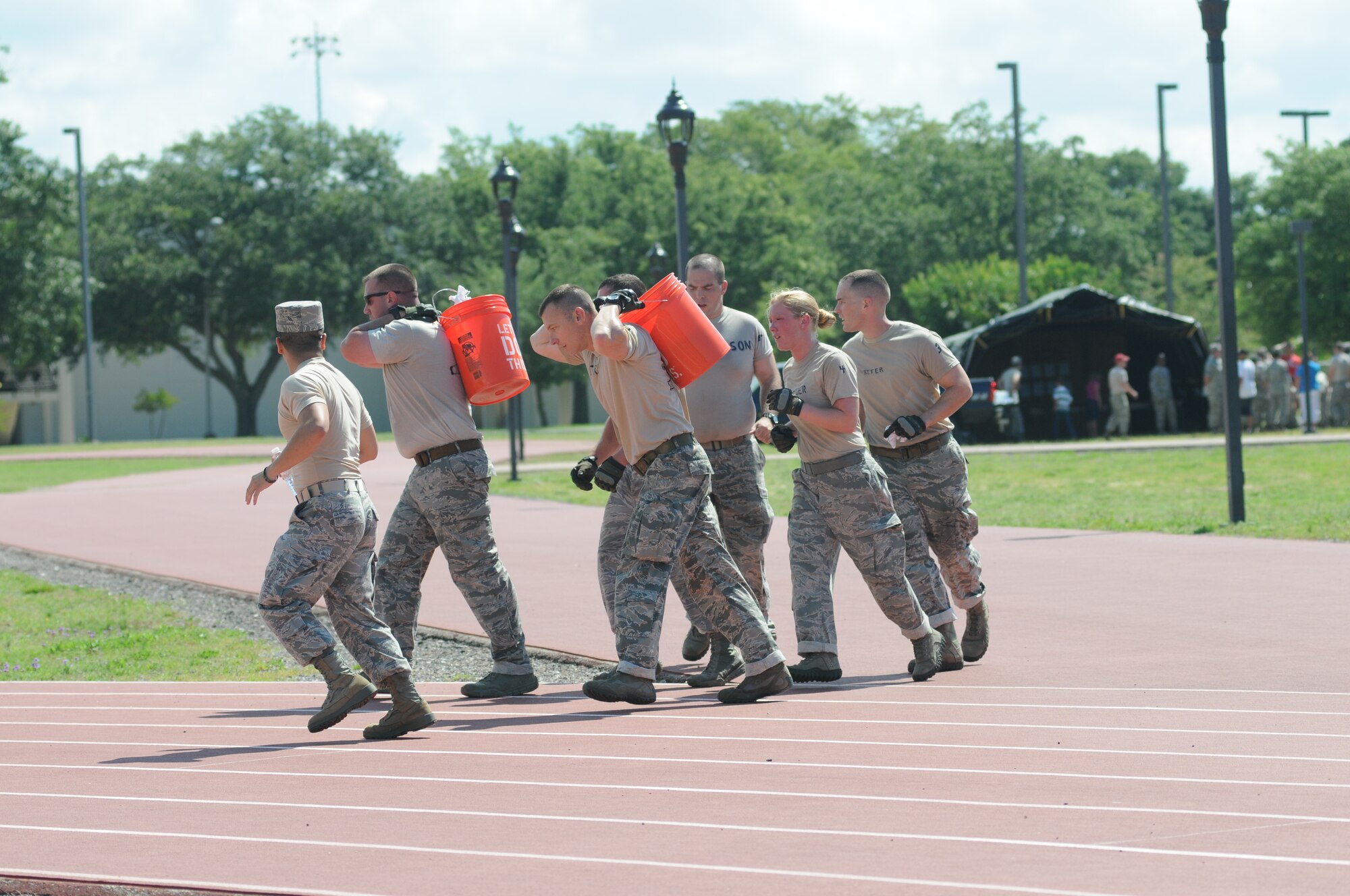 Ricky & The Bayonets team members from the 81st Security Forces Squadron compete in the final challenge, the “Mogadishu Mile,” which is a one-mile run while carrying buckets of sandbags during the 81st Training Wing Warrior Challenge hosted by the 81st Mission Support Group June 6, 2014, at the Triangle Track, Keesler Air Force Base, Miss.  The event was held in memory of the 70th anniversary of The Normandy Invasion also known as D-Day.  It consisted of nine six-member teams racing in a competition designed to take them through various aspects of a deployment. Ricky & The Bayonets placed first in the competition.  (U.S. Air Force photo by Kemberly Groue)