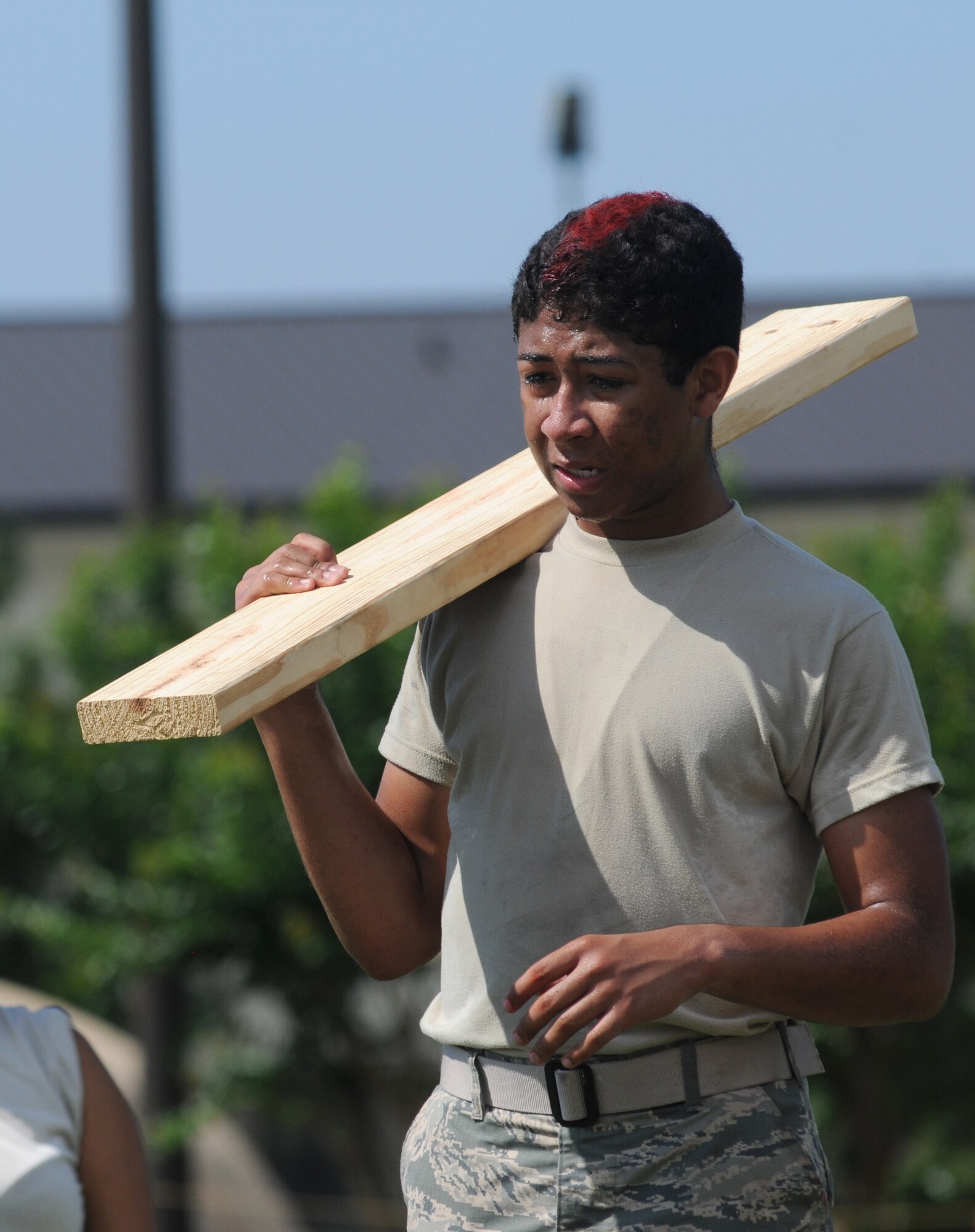 The Logistics Readiness Squadron Warriors team member, Airman 1st Class Cameron Spriggs, holds onto a piece of wood during the “’X’ Factor” challenge during the 81st Training Wing Warrior Challenge hosted by the 81st Mission Support Group June 6, 2014, at the Triangle Track, Keesler Air Force Base, Miss.  The challenge required the whole team to work their way through a maze using only cinderblocks and various length pieces of wood without touching the ground.  The event was held in memory of the 70th anniversary of The Normandy Invasion also known as D-Day.  (U.S. Air Force photo by Kemberly Groue)