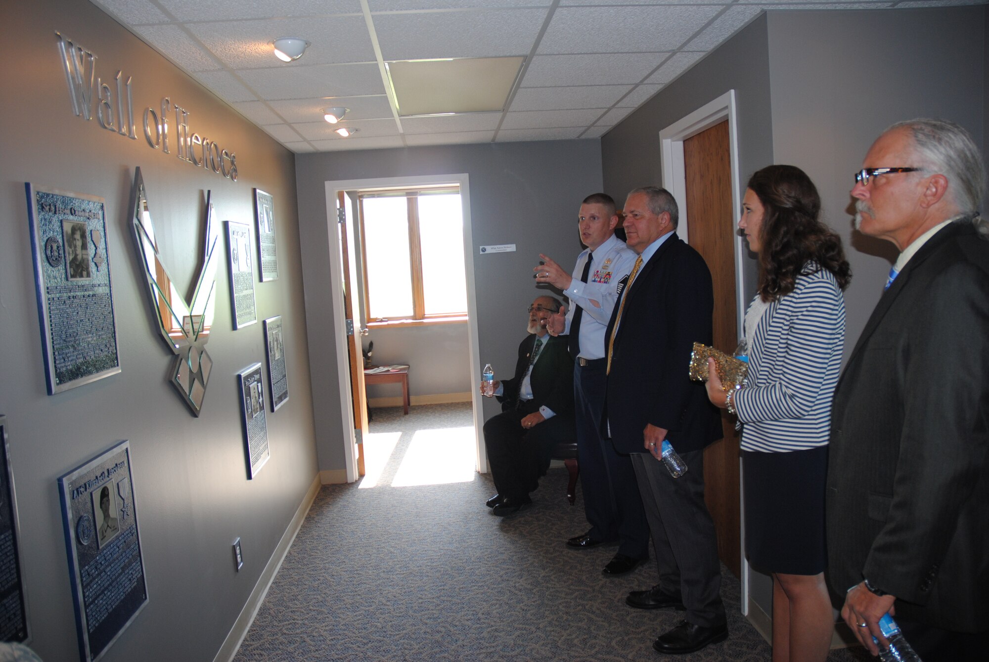 Master Sgt. Aaron Holmes, Chief Master Sgt. Richard L. Etchberger Airman Leadership School commandant, shows members of the Etchberger family the Wall of Heroes inside the ALS on Grand Forks Air Force Base, N.D., June 4, 2014. The Wall of Heroes is one of the memorials for service members located inside the school recently dedicated to the memory of the heroic Air Force Senior NCO. (U.S. Air Force photo/Staff Sgt. Luis Loza Gutierrez) 
