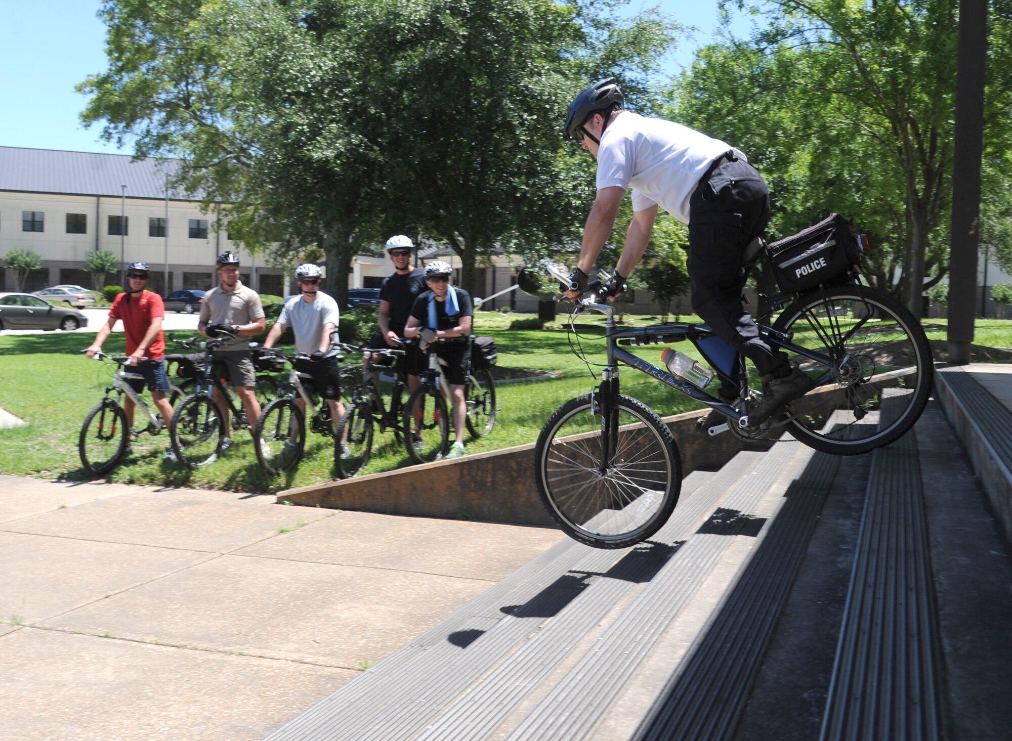 Warren Breckinridge, 81st Security Forces Squadron unit trainer, demonstrates to 81st SFS Airman how to steady a patrol bike while descending stairs during a bicycle training class June 4, 2014, at Bryan Hall, Keesler Air Force Base, Miss.  The 81st SFS held a five-day bicycle training class June 2-6, 2014, for Keesler law enforcement Airmen which consists of bike safety, road hazards, proper stopping, use of bike as a defense mechanism, and dismounts at high speed as well as a total bike ride of over 100 miles. Bike patrols are a stealthy and versatile option for security forces officers, which can be used for special events, community policing, and crime prevention. (U.S. Air Force photo by Kemberly Groue)