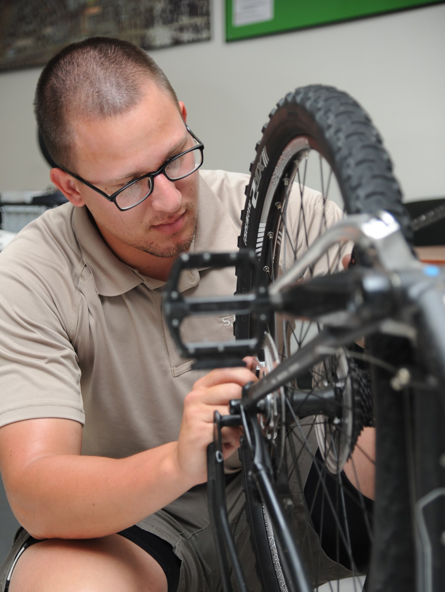 Airman 1st Class Joseph Prescott, 81st Security Forces Squadron, replaces a tire on his patrol bike during a bicycle training class June 4, 2014, at the 81st SFS building, Keesler Air Force Base, Miss.  The 81st SFS held a five-day bicycle training class June 2-6, 2014, for Keesler law enforcement Airmen which consists of bike safety, road hazards, proper stopping, use of bike as a defense mechanism, and dismounts at high speed as well as a total bike ride of over 100 miles. Bike patrols are a stealthy and versatile option for security forces officers, which can be used for special events, community policing, and crime prevention. (U.S. Air Force photo by Kemberly Groue)