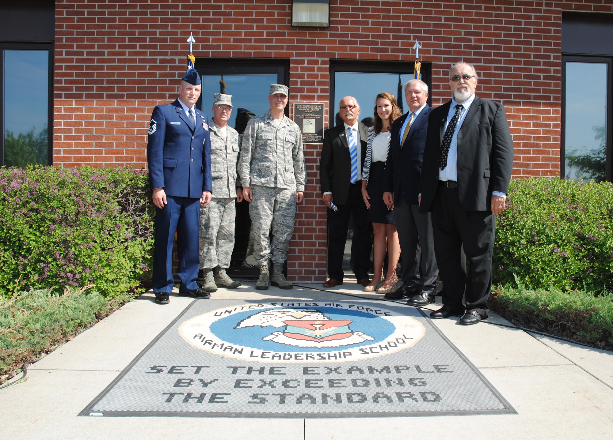 (From left to right) Master Sgt. Aaron Holmes, Chief Master Sgt. Richard L. Etchberger Airman Leadership School commandant, Chief Master Sgt. David Duncan, 319th Air Base Wing command chief, and Col. Paul Bauman, 319th ABW commander, pose for a group photo with four members of the Etchberger family after unveiling the plaque commemorating the dedication of the school in honor of Chief Etchberger, June 4, 2014, during a ceremony on Grand Forks Air Force Base, N.D.  (U.S. Air Force photo/Staff Sgt. Luis Loza Gutierrez) 
