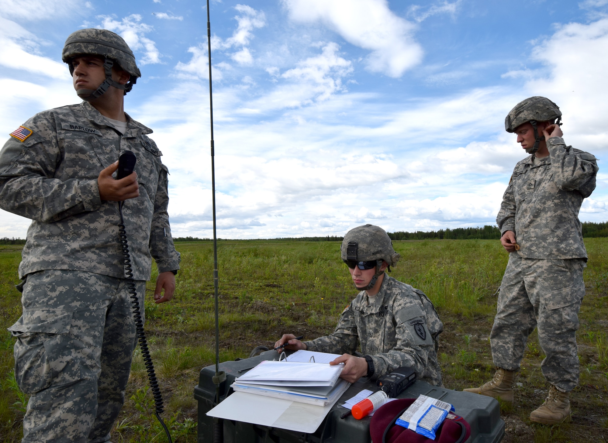 Soldiers with the 4th Infantry Brigade Combat Team (Air Borne), 25th Infantry Division coordinate with incoming paratroopers  on Joint Base Elmendorf-Richardson, Alaska, as part of a Joint Force Entry Exercise on June 7, 2014. The six-day exercise involved over 1,500 personnel including active duty Army, Air Force and Air National Guard. ( U.S. Air National Guard photo by Captain John Callahan/ Released)