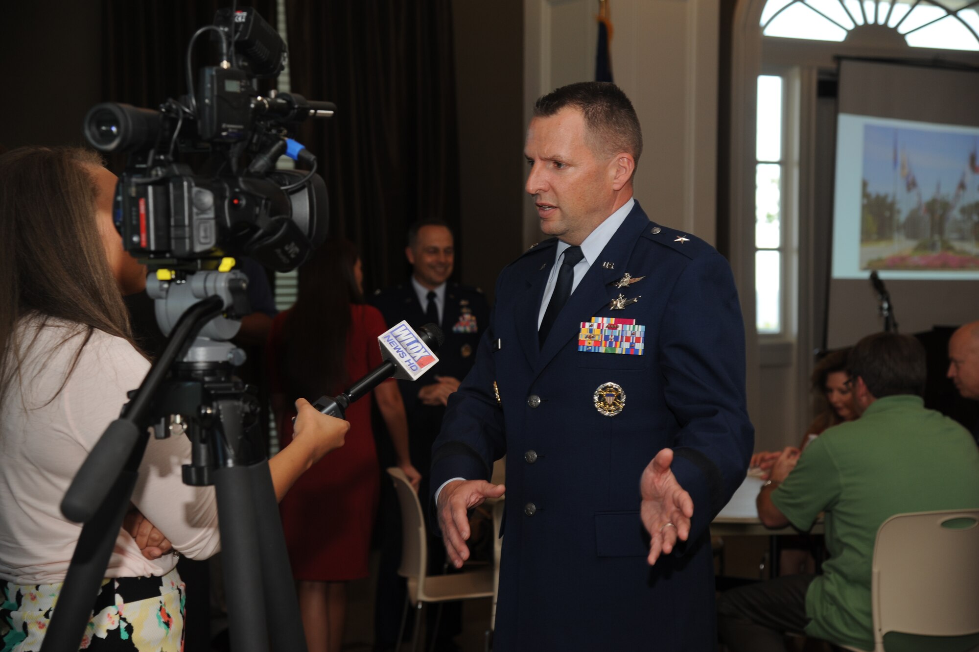 Brig. Gen. Patrick Higby, 81st Training Wing commander, Keesler Air Force Base, Miss., is interviewed by a local news station, WLOX, during the Biloxi Chamber of Commerce flag sponsor appreciation reception June 4, 2014, at the Biloxi visitors center. Over 55 sponsors donated funds to support the base with purchasing two sets of the 50 state flags and six territory flags that hang on display as you enter the base on Larcher Blvd.  (U.S. Air Force photo by Kemberly Groue)