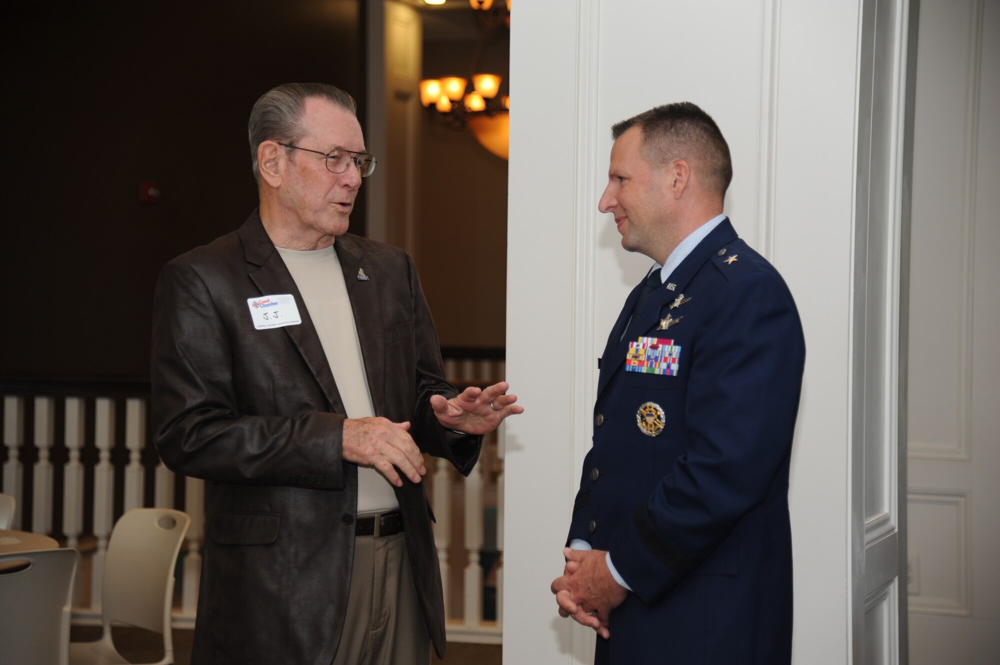 Retired Chief Master Sgt. J.J. Vollmuth and Brig. Gen. Patrick Higby, 81st Training Wing commander, Keesler Air Force Base, Miss., have a discussion during the Biloxi Chamber of Commerce flag sponsor appreciation reception June 4, 2014, at the Biloxi visitors center.  Vollmuth served as a board member on the local Air Force Association (John C. Stennis) Chapter who helped spearhead a campaign to raise money for the very first set of flags and flagpoles on Larcher Blvd. at Keesler.  (U.S. Air Force photo by Kemberly Groue)