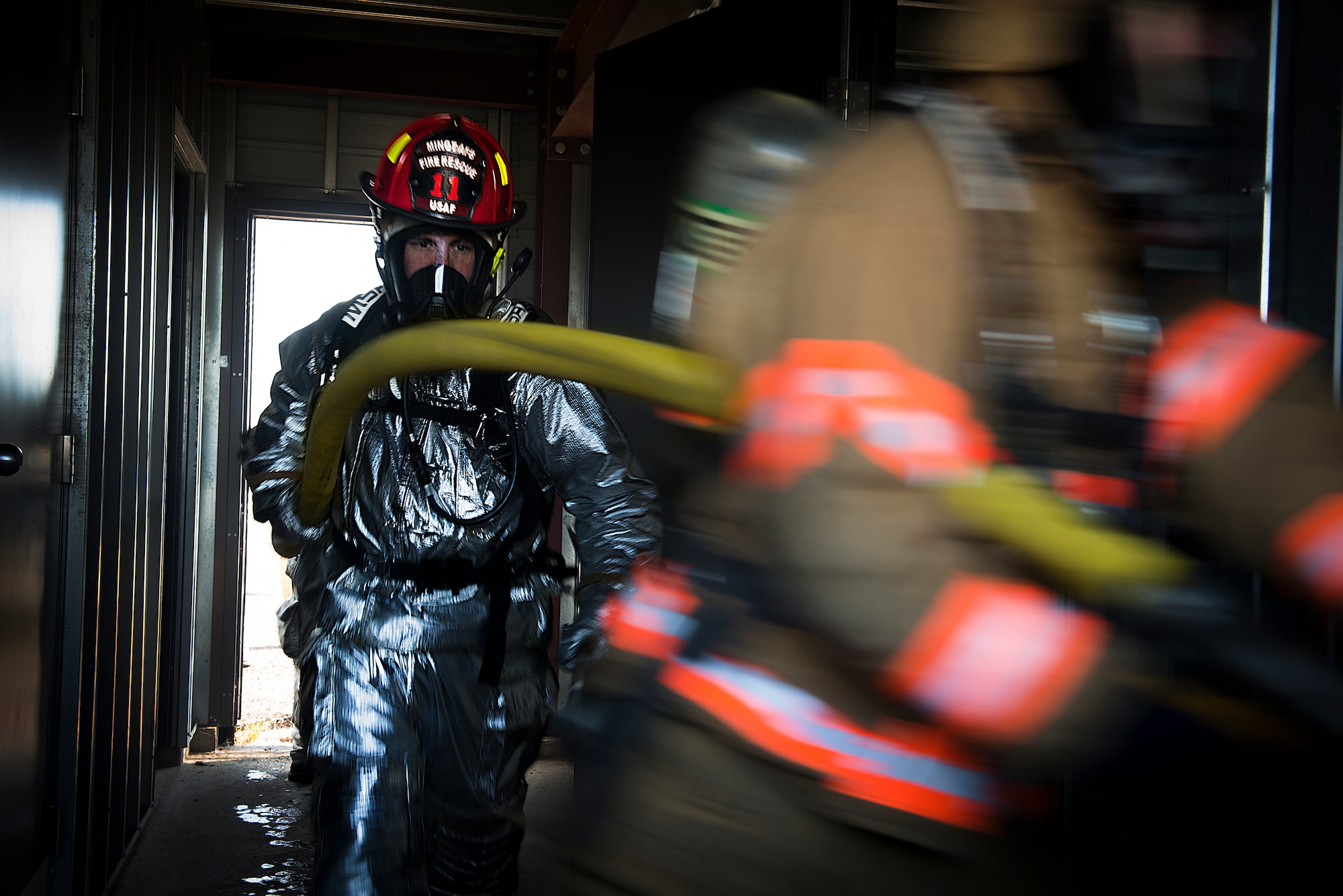 Firefighters from the 5th Civil Engineer Squadron participate in a controlled burn exercise at Minot Air Force Base, N.D. The fire training facility provides realistic training for the fire fighters with controlled flames emanating from specific areas of the building, and can be used in any type of weather to increase readiness of base and local community firefighters. (U.S. Air Force photo/Airman 1st Class Sahara Fales)