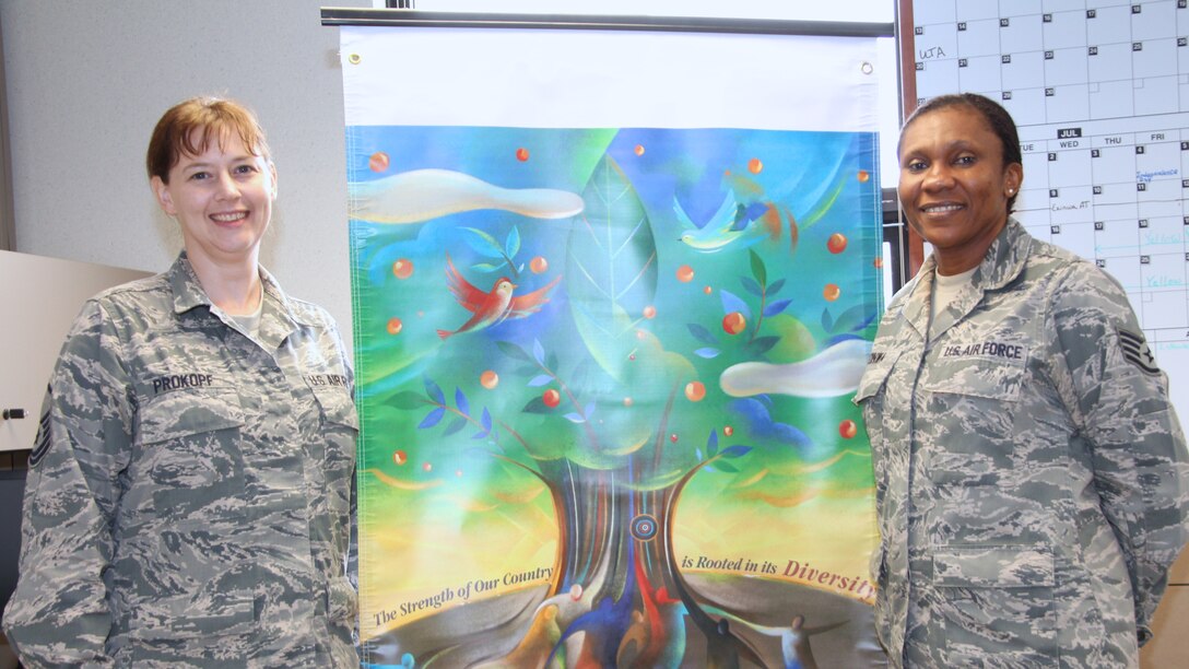 932nd Airlift Wing's Equal  Opportunity superintedent Master Sgt. Heather Prokopf shows off a new banner as she trains the new EO advisor Staff Sgt. Nonny Eninwa. (U.S. Air Force Photo/Staff. Sgt. Meiko Schill)
