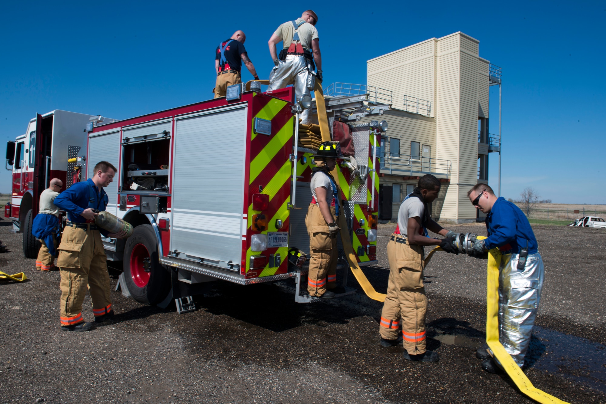 Firefighters from the 5th Civil Engineer Squadron participate in a controlled burn exercise at Minot Air Force Base, N.D. The fire training facility provides realistic training for the fire fighters with controlled flames emanating from specific areas of the building, and can be used in any type of weather to increase readiness of base and local community firefighters. (U.S. Air Force photo/Airman 1st Class Sahara Fales)