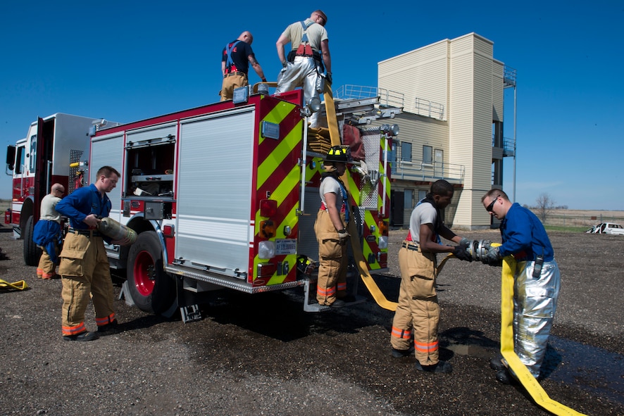 Firefighters from the 5th Civil Engineer Squadron participate in a controlled burn exercise at Minot Air Force Base, N.D. The fire training facility provides realistic training for the fire fighters with controlled flames emanating from specific areas of the building, and can be used in any type of weather to increase readiness of base and local community firefighters. (U.S. Air Force photo/Airman 1st Class Sahara Fales)