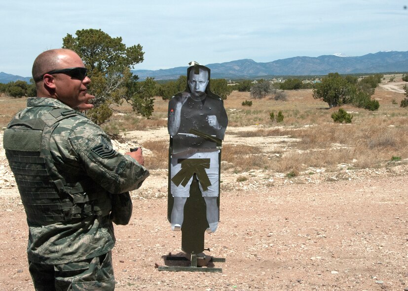 U.S. Air Force Tech. Sgt. Jeffrey Clark, 233d Secuity Forces Squadron Training Manager, Colorado Air National Guard, demonstrates how to properly aim and deliver a shock from a Taser X26 Conducted Electrical Weapon to a simulated casualty at Airburst Range, Fort Carson, Colo., May 5, 2014.  The 233 SFS Airmen are completing a four day annual combat readiness course that focuses on air expeditionary, force on force and heavy weapons training and includes a variety of day and night missions. (U.S. Air National Guard photo by Senior Airman Michelle Y. Alvarez-Rea)