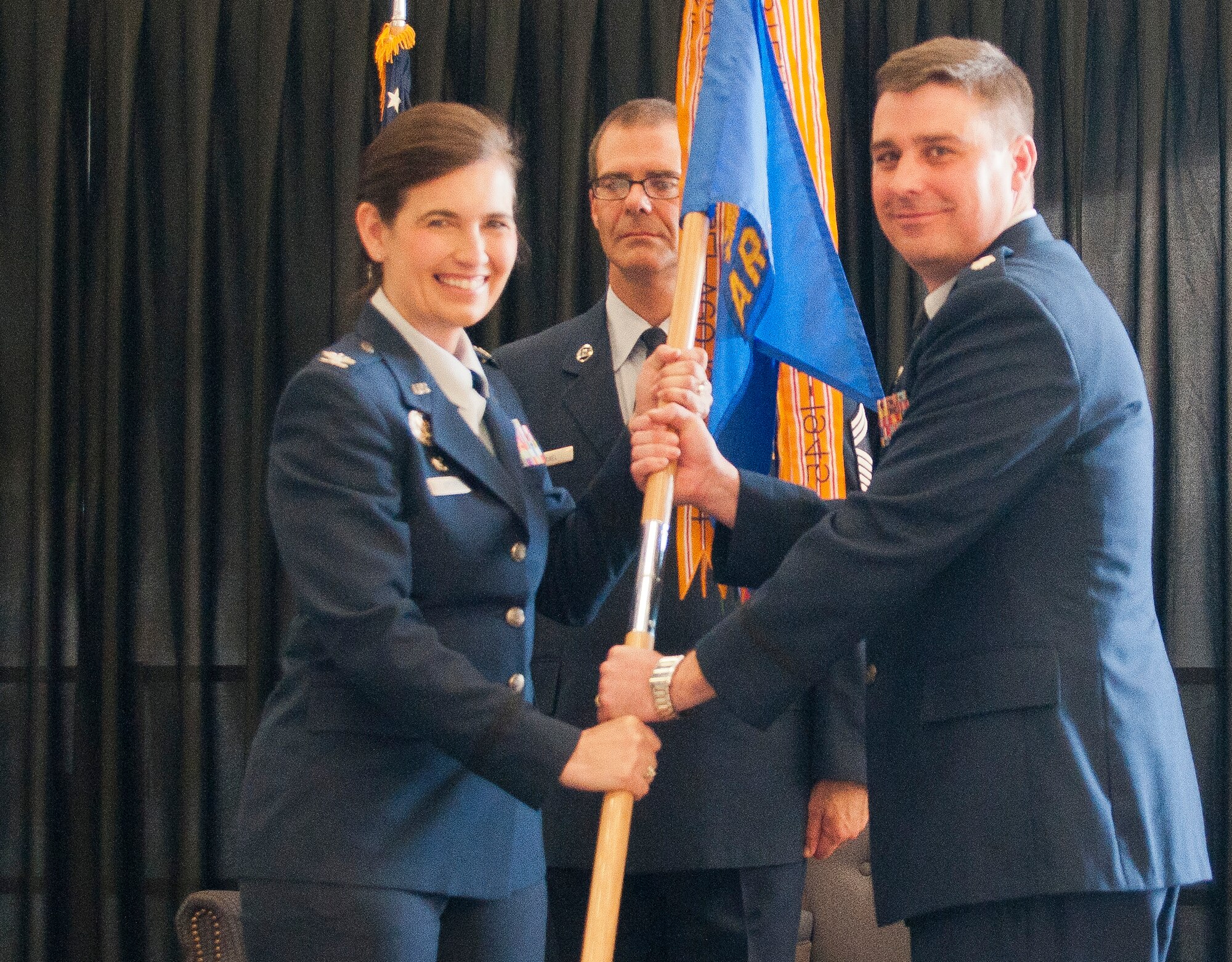 U.S. Air Force Lt. Col. Bradley Stevens, Commander, 64th Air Refueling Squadron (right) , accepts the 64 ARS guideon from U.S. Air Force Col. Jennifer Uptmor (left), Commander, 22nd Operations Group, McConnell Air Force Base, K.A. signifying his assuming command, Pease ANGB, June 8, 2014.