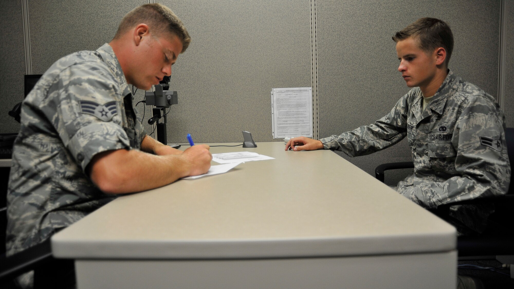 Senior Airman James Johnson, 325th Force Support Squadron customer support floor supervisor, assists Airman 1st Class Austin Walker, 325th Maintenance Squadron low observable technician, with paper work June 10 at the Military Personnel Support customer support center. The MPS customer support center issues identifications such as Common Access Cards. (U.S. Air Force photo by Airman 1st Class Solomon Cook)  

