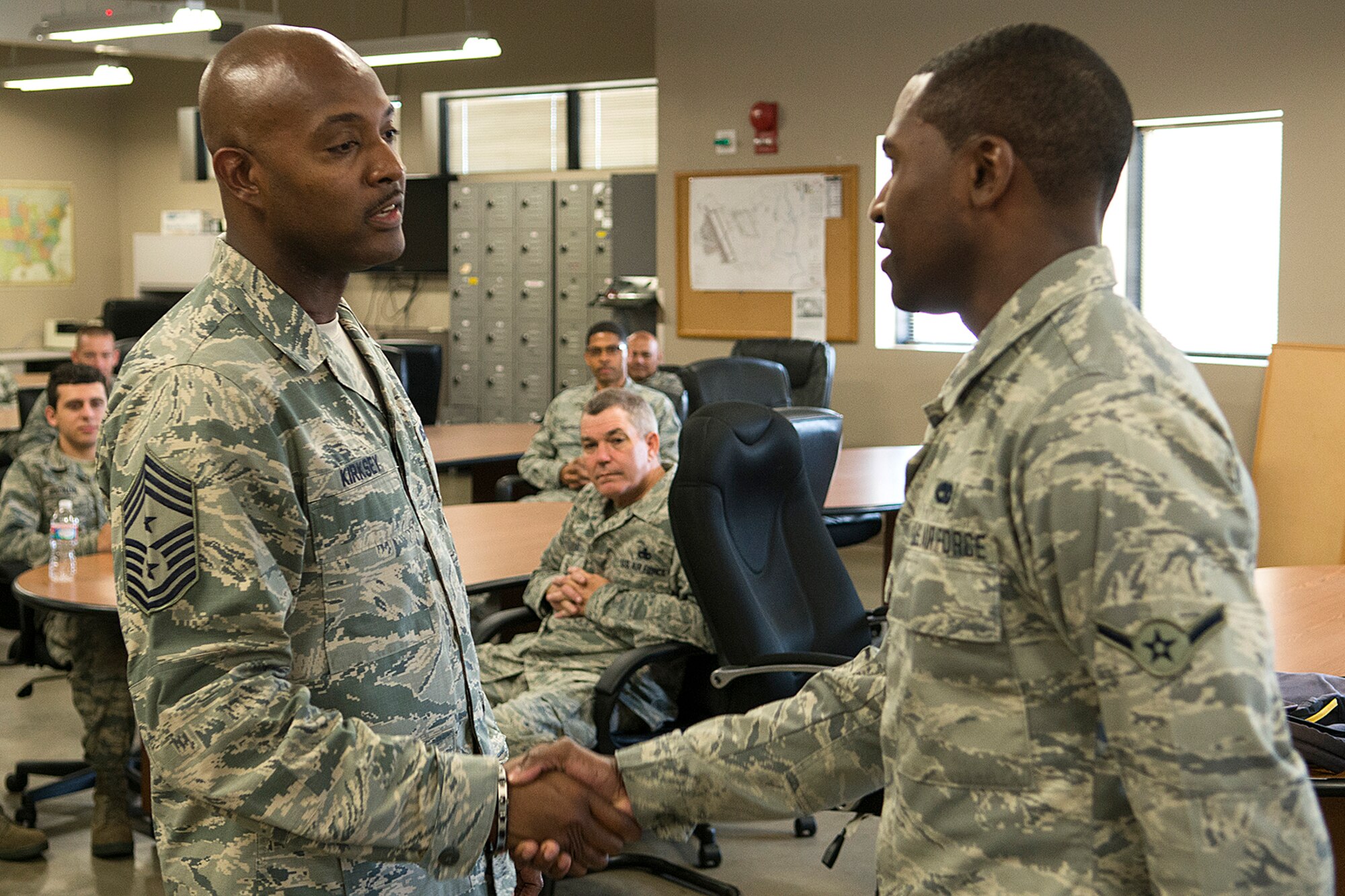 U.S. Air Force Reserve Command (AFRC) Chief Master Sgt. Cameron Kirksey recognizes Airman Joseph Moore, June 8, 2014, Barksdale Air Force Base, La. Moore, assigned to the 307th Maintenance Squadron, was selected by his supervisors for his outstanding professionalism and is presented the AFRC Command Chief's coin during the handshake. (U.S. Air Force photo by Master Sgt. Greg Steele/Released)
