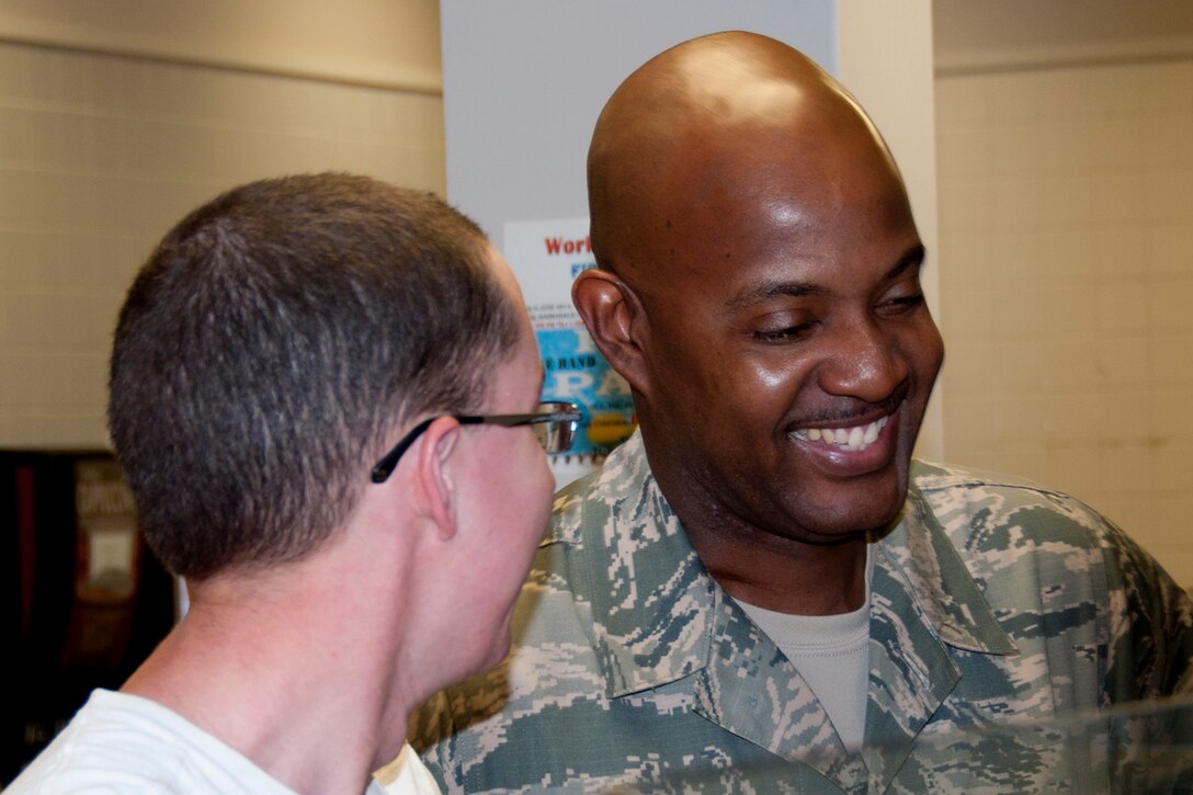 U.S. Air Force Reserve Command Chief Master Sgt. Cameron Kirksey, shares a laugh with an off-duty Airman while going through the dining facility at Barksdale Air Force Base, La., June 7, 2014. Kirksey has breakfast with a group of junior enlisted members of the 307th Bomb Wing to listen to their concerns and answer questions they had about the current state of the Air Force Reserve and plans for the future. (U.S. Air Force photo by Tech. Sgt. Ted Daigle/Released)