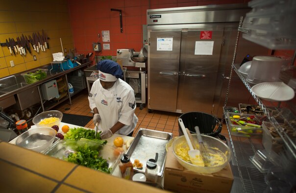 Senior Airman Audreianna Johnson, 5th Force Support Squadron chef, cuts lettuce at the Dakota Inn dining facility at Minot Air Force Base, N.D., June 5, 2014. The dining facility staff works around the clock preparing and serving meals for Airmen. (U.S. Air Force photo/Airman 1st Class Apryl Hall)