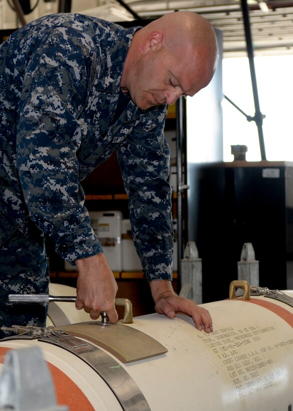 Petty Officer 1st Class Jeremy Frick, Naval Munitions Command Seal Beach mineman, prepares an Mk-65 Quickstrike mine during a joint training mission at Ellsworth Air Force Base, S.D., June 2, 2014. The U.S. Navy partnered with Ellsworth Airmen, completing tasks that involved land, sea and air components. (U.S. Air Force photo by Senior Airman Anania Tekurio/Released)