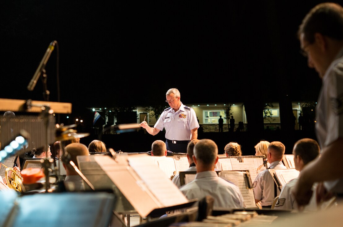 Commander Major Roger Mills conducts the concert band during a performance