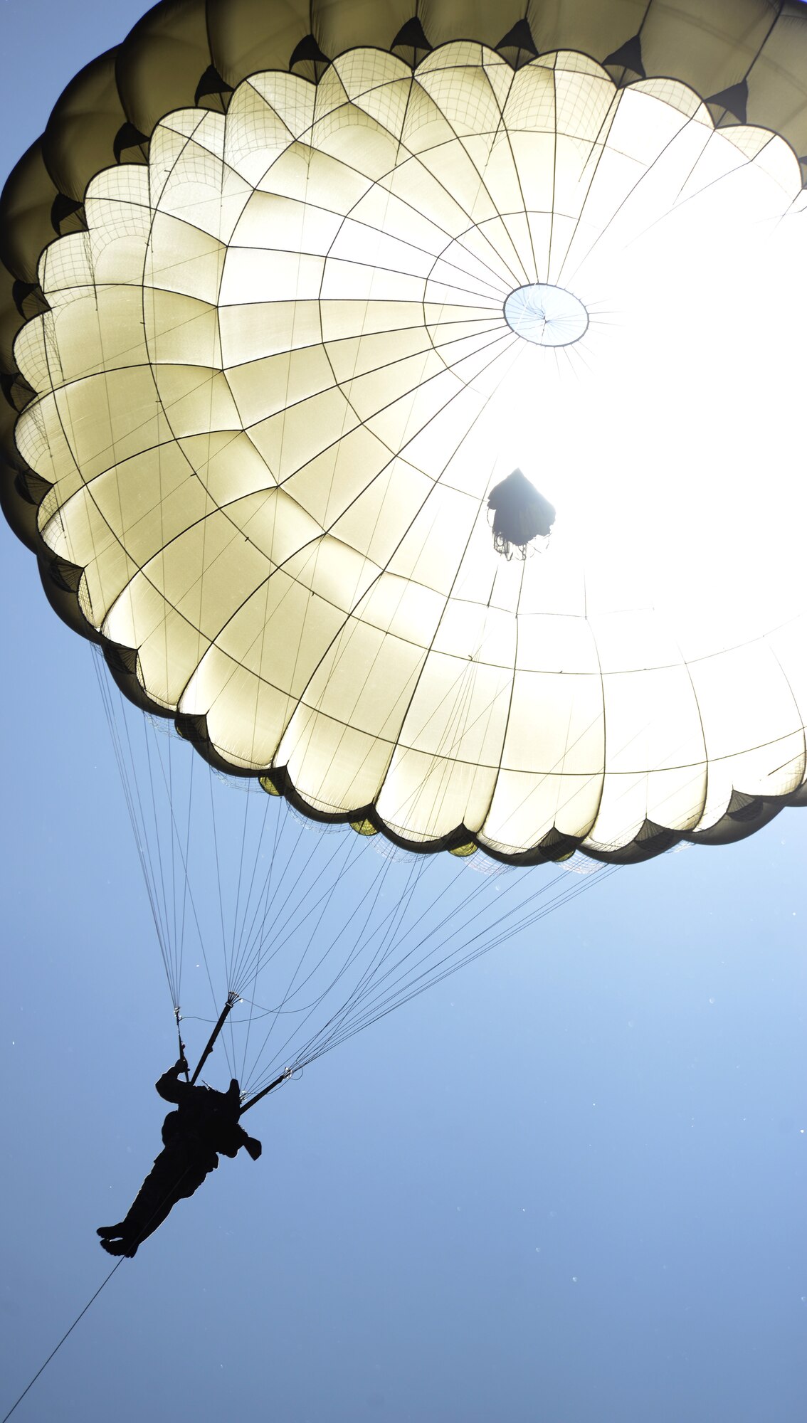 A paratrooper descends onto the Iron Mike Drop Zone outside St. Mere Eglise, France during the 70th anniversary celebration of D-Day June 8, 2014. More than 700 static-line paratroopers jumped into the drop zone from 14 different aircraft from nations around the world. (U.S. Air Force photo/Airman 1st Class Dillon Johnston/Released)