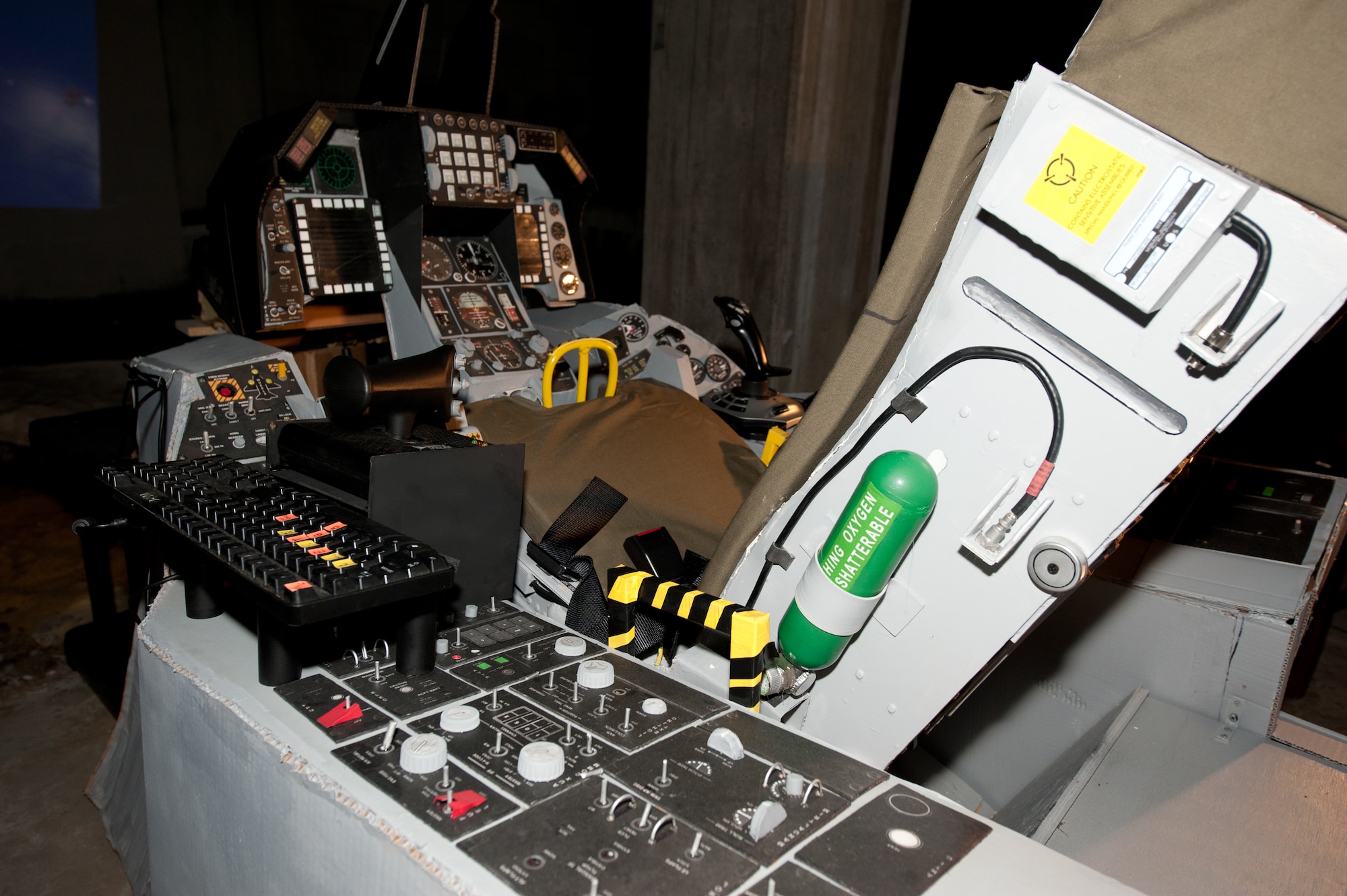 Made from recycled cardboard, bottle caps, an old entertainment center and other reclaimed materials, David Gatling has built a “green” F-16 simulator in the basement of his apartment complex in Newport News, Va. Gatling said the simulator is almost identical, except for materials, to a commercially-made one. (U.S. Air Force photo by Melissa Walther/Released)