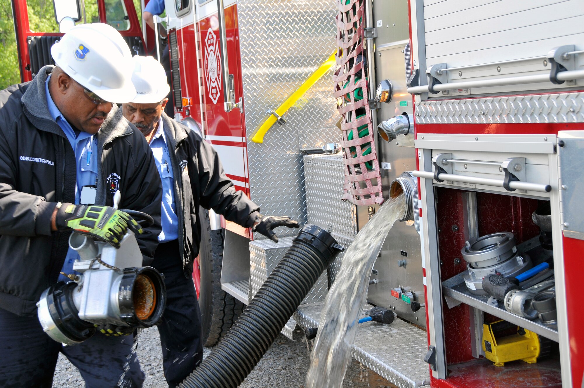 Members of the Capitol Hill and Arnold Air Force Base fire departments work together to perform a first draft of the dry hydrant installed at Morris Ferry Dock. Pictured in the first photo are Capitol Hill fire personnel hooking the fire truck up to the dry hydrant. As seen in the second photo, the fire hose successfully sprays water from the lake. Pictured in the last photo are AEDC fire personnel Odell Crutchfield (left) and Billy King (right) assisting in detaching equipment from the truck. (Photos by Jacqueline Cowan)