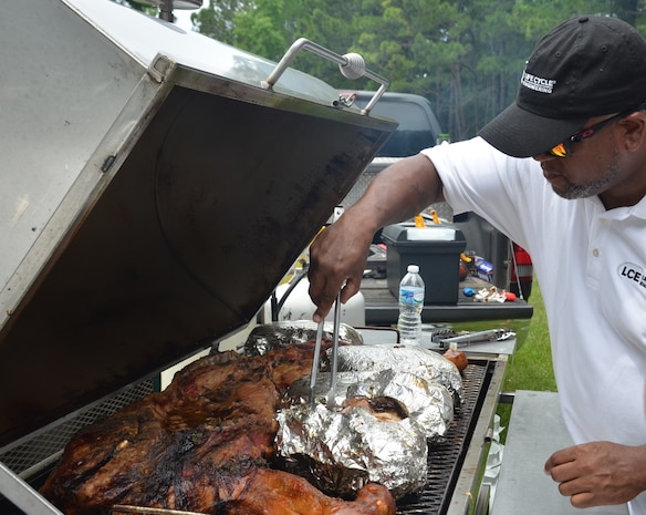 If it looks like a pig and smells really good ... EAT IT! Naval Support Activity held a BBQ and pig picking June 6, 2014, at Storm Pointe Conference Center on Joint Base Charleston - Weapons Station. One and half hogs and numerous pork butts were slow cooked and served up  with beans, cole slaw and macaroni and cheese during lunch to raise money for the upcoming Navy Ball. (U.S. Air Force photo/Eric Sesit)
