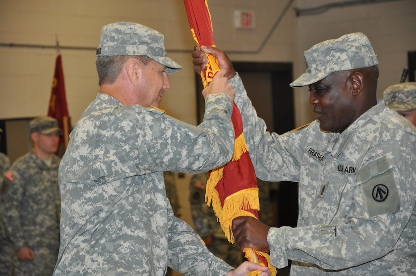 Colonel Stephen M. Rutner, passes his command guidon to 1189th Transportation Surface Brigade’s Command Sergeant Major Adolph Fraser, during a change of command ceremony June 8, 2014, at the Thomas H. Martin Reserve Center on Joint Base Charleston - Weapons Station, S.C. (U.S. Army photo/Cadet Sherril E. Rawlinson)