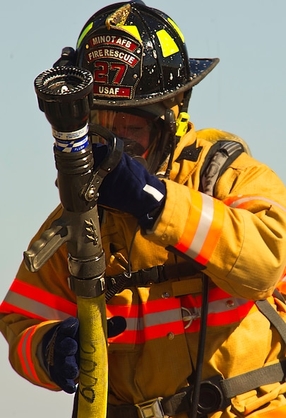 Firefighters from the 5th Civil Engineer Squadron check their equipment before participating in a controlled burn exercise at Minot Air Force Base, N.D., May 21, 2014. The fire training facility provides realistic training for the fire fighters with controlled flames emanating from specific areas of the building, and can be used in any type of weather to increase readiness of base and local community firefighters. (U.S. Air Force photo/Senior Airman Brittany Y. Bateman)