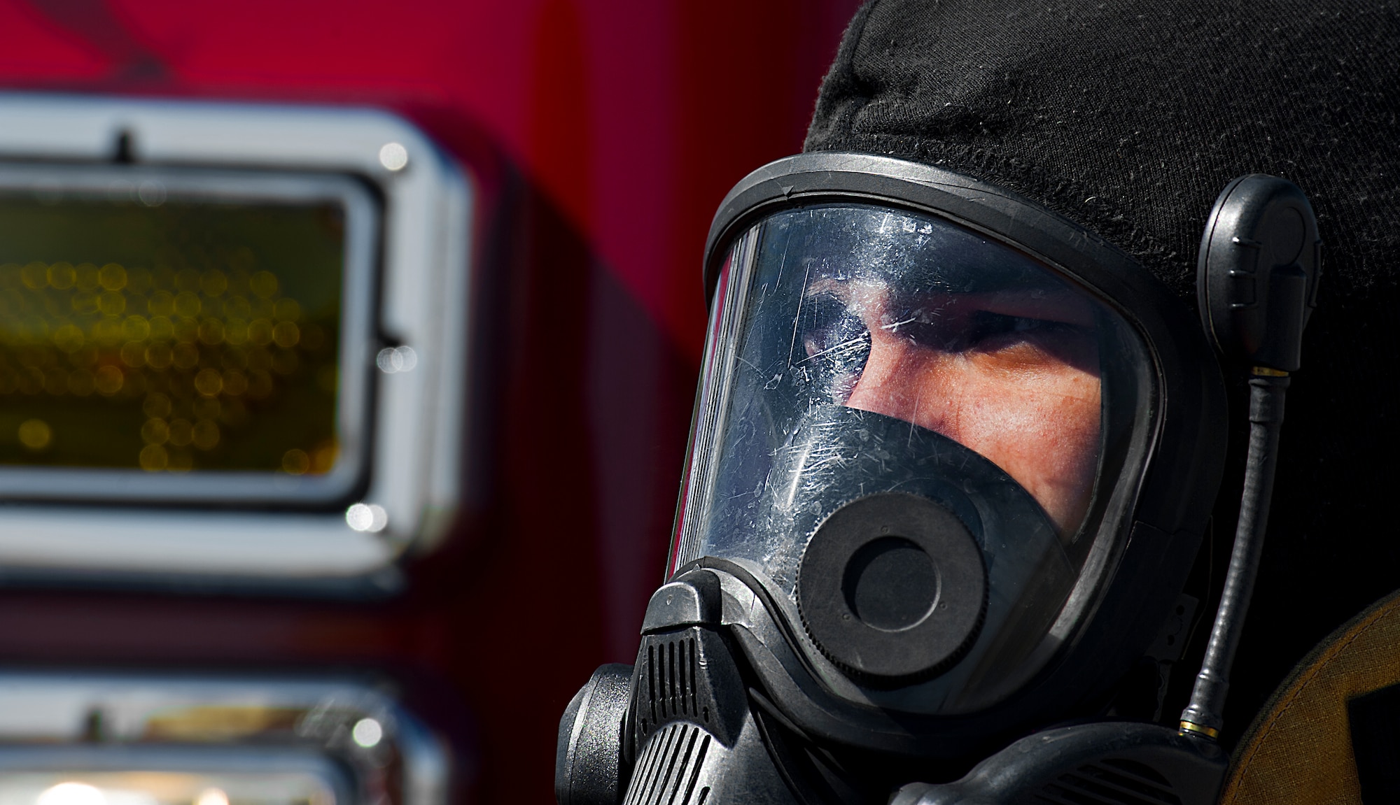 A firefighter from the 5th Civil Engineer Squadron dons his gas mask before participating in a controlled burn exercise at Minot Air Force Base, N.D., May 21, 2014. The multi-use structure provides an ability to train firefighters at all levels, from hose evolutions to command and control scenarios. It has movable walls to change room layout, and can test firefighter skills conducting search patterns and victim locating in blackout conditions. It provides opportunity for forcible entry training, confined space rescue, and offers realistic and scenario based sounds during training to add to the realism. (U.S. Air Force photo/Senior Airman Brittany Y. Bateman)