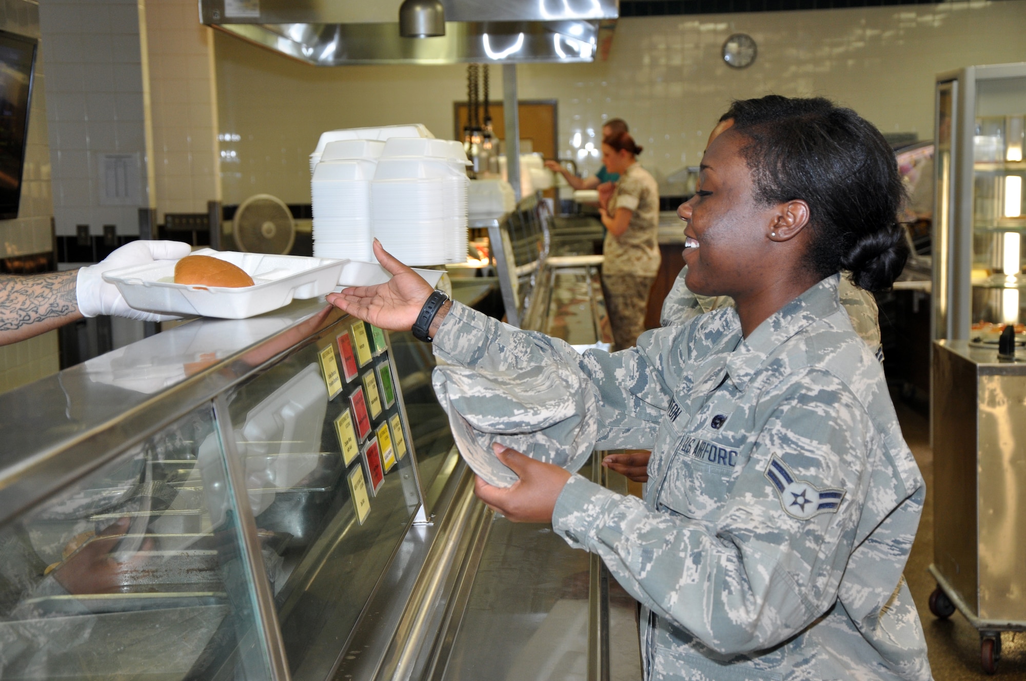 GOODFELLOW AIR FORCE BASE, Texas – Airman 1st Class Jebree M. Hinton, 17th Training Wing Legal Office Military Justice paralegal, receives her grilled sandwich at the Cressman Dining Facility May 6. Hinton and some other permanent party personnel as well as students already have meals deducted from their pay, so they do not need to worry about paying at the checkout. (U.S. Air Force photo/ Senior Airman Joshua Edwards)
